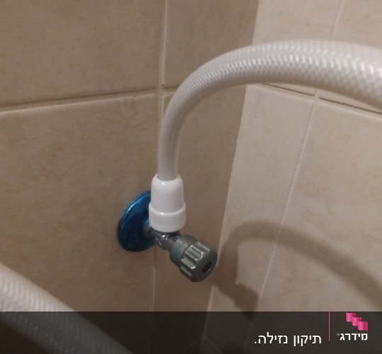 צינור מים מחובר לברז בקיר